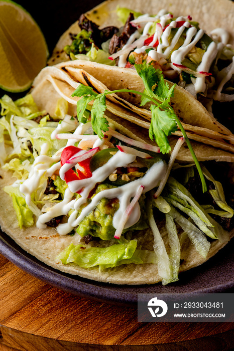 Tacos. Crispy flour and corn tortillas filled with sausage, bacon, beef, cheese, sour cream, salsa and guacamole and served with rice and beans. Classic Tex-Mex or Mexican restaurant entrée favorite.