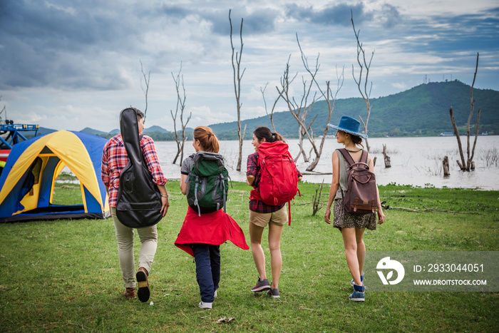 Group of Traveler Walking to Outdoor Camping Near the Lake for Hiking in Weekend Summer - Holiday Travel and Recreation Concept