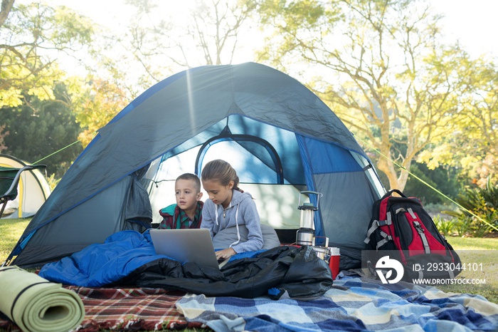 Kids using laptop in the tent