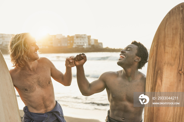 Multiracial surfer men having fun on the beach - Happy young people doing extreme sport together