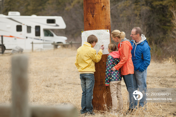 family reviewing a map at their campsite