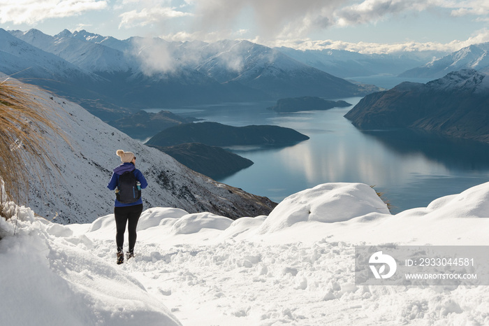 Woman walking in the snow of Roy’s Peak Track. Wanaka, New Zealand