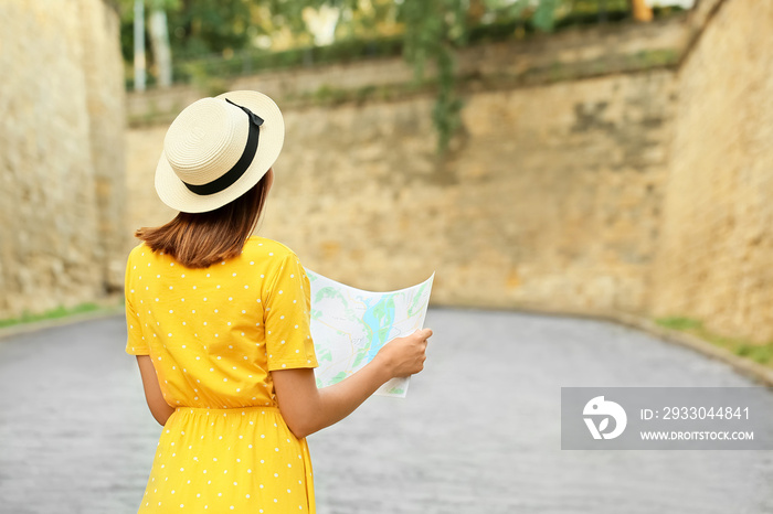 Young female tourist with map outdoors