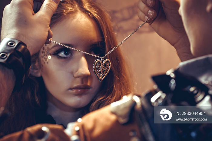 Portrait of a young beautiful loving couple in steampunk style.