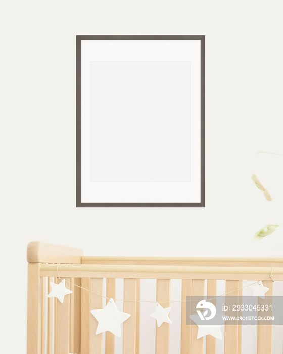 Mock up poster frame in children room, nursery room with wooden crib for kids with white ceramic stars, close-up, white wall, scandinavian style