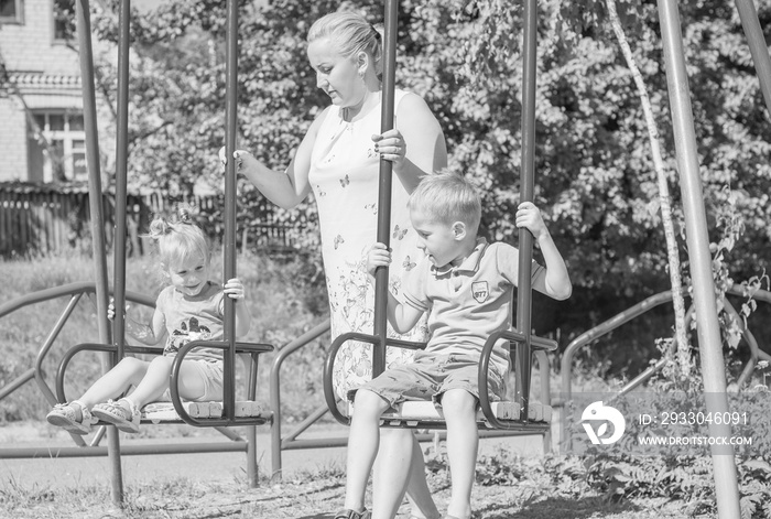 Mom with two children walking outdoor, warm weather. Lifestyle portrait mom and kids in happiness at the outside, vacation moments