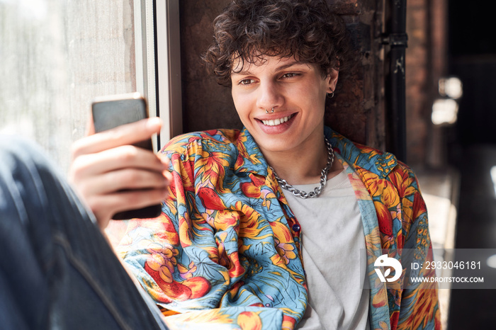 Smiling guy looking at his smartphone screen