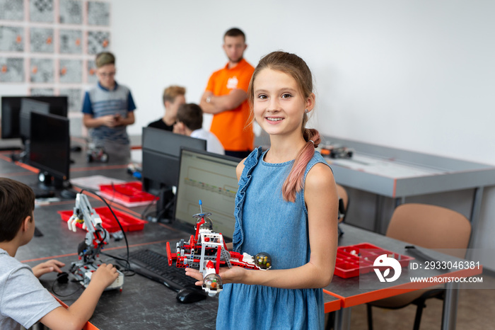 Portrait Of Female Student Building Robot Vehicle In After School Computer Coding Class.