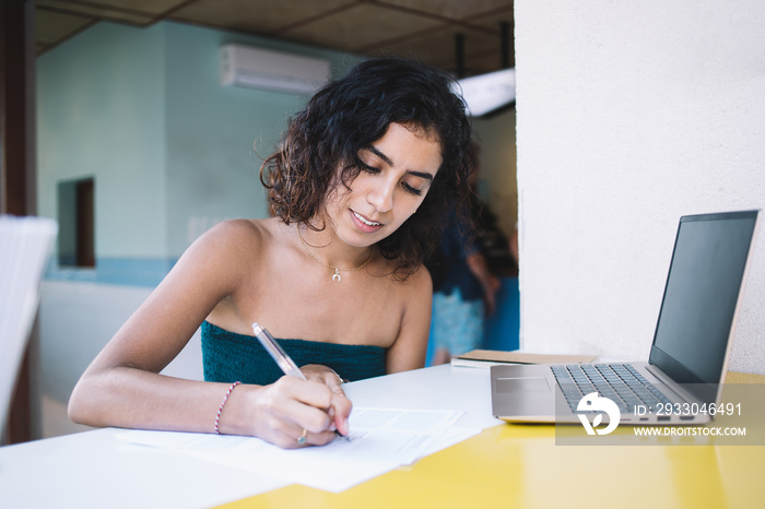 Concentrated female doing homework using laptop