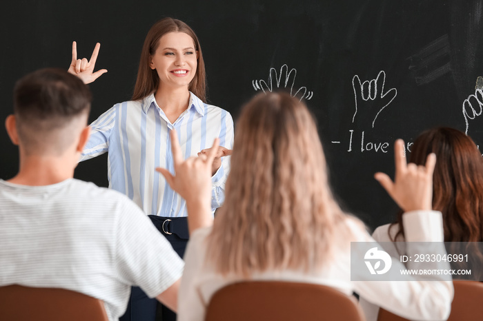 Teacher conducting courses for deaf mute people in classroom