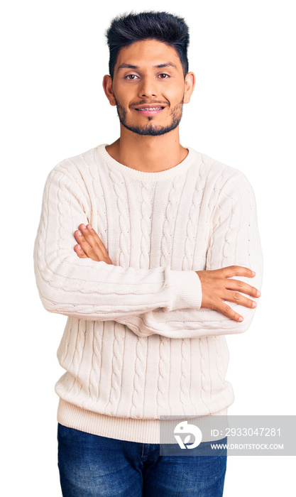 Handsome latin american young man wearing casual winter sweater happy face smiling with crossed arms looking at the camera. positive person.