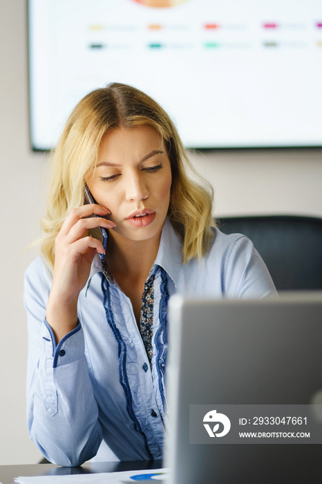 Young adult caucasian woman having a phone call at work - Beautiful girl at work looking worried while receiving bad tragic a news via phone - Female using phone receiving report at office in day