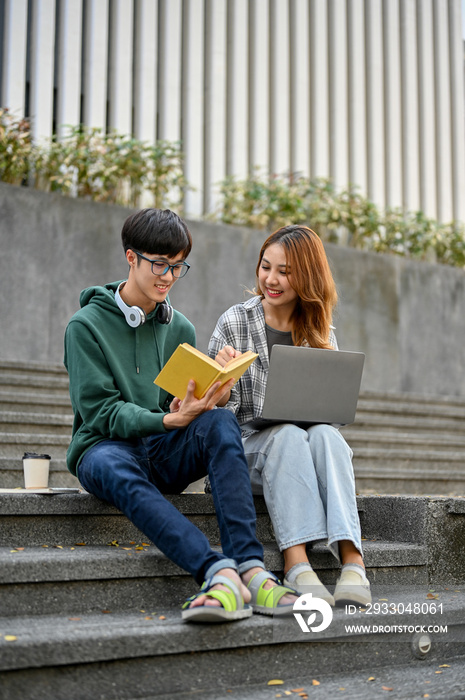 Happy young Asian college students are sharing ideas, working on their school project together