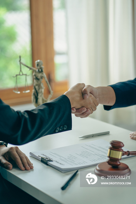 Businessmen shake hands after consulting the law from lawyers, judges, and legal counsel. Consulting services on various contracts to plan a court case with hammers and scales next to