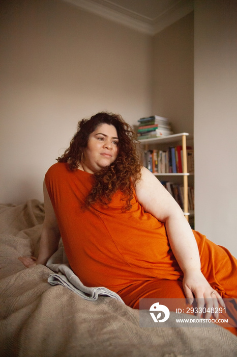 Plus-sized Sri Lankan woman with vitiligos sitting on her bed