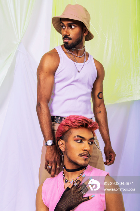 Malaysian Indian men posed in front of a cloth backdrop in a studio setting