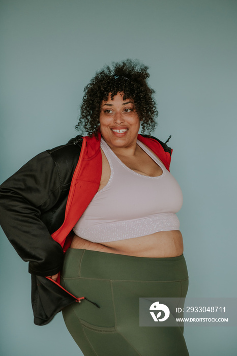 portrait of a plus size afro indigenous person smiling and wearing workout gear