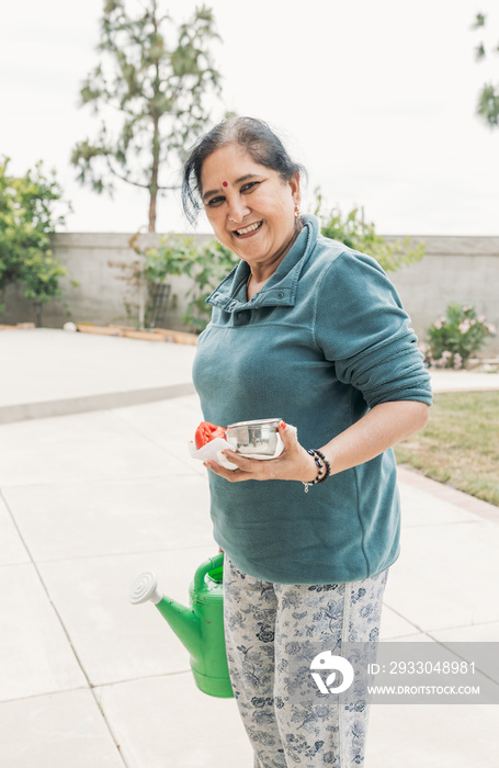 South Asian woman gardening in backyard