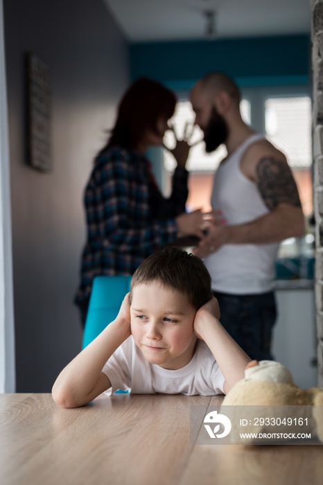 Sad, desperate little boy during parents quarrel