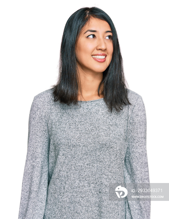 Beautiful asian young woman wearing casual clothes looking away to side with smile on face, natural expression. laughing confident.