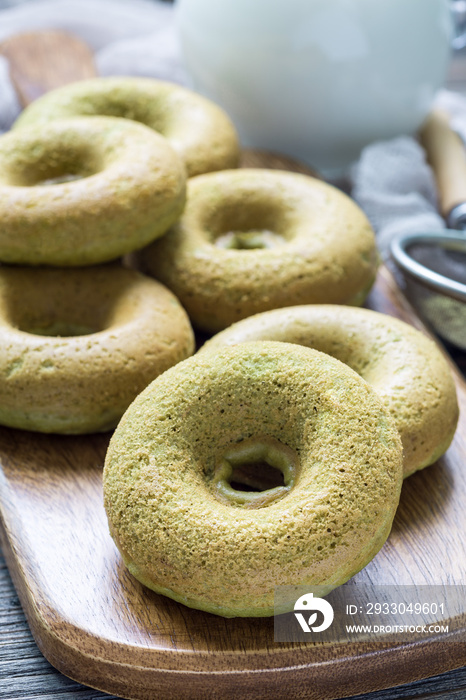 Freshly baked matcha banana donuts on wooden board