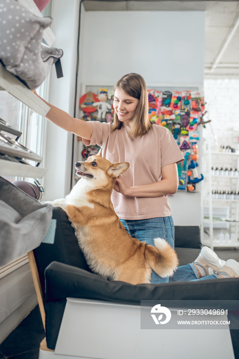 A smiling girl choosing animal accessories in a pet shop