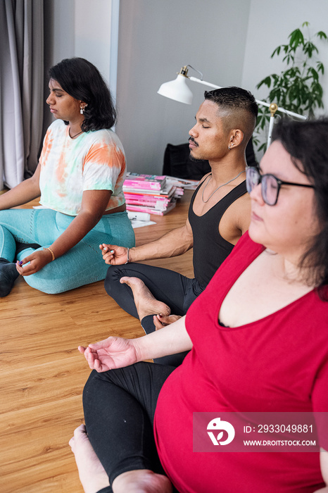 Group of friends meditating and doing yoga at home