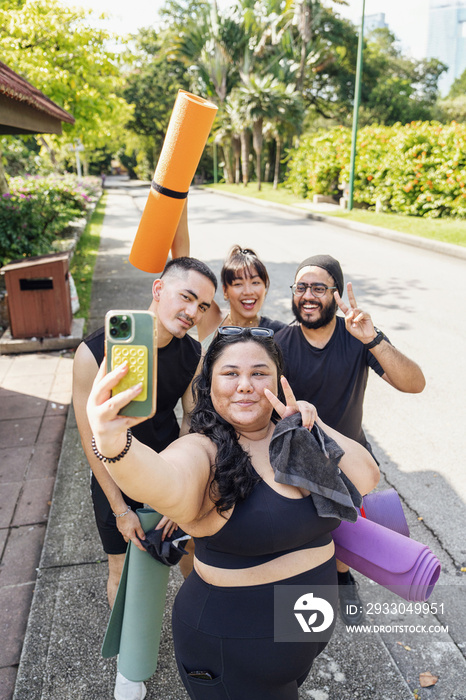 Group of friends taking a selfie together in the park after working out