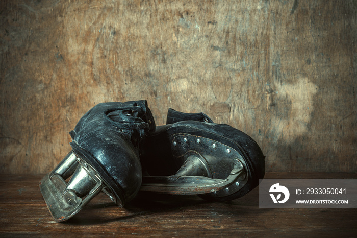 Old black leather skates on a wooden table in a retro style