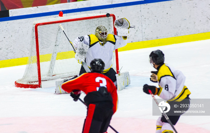 Ice hockey player shoots the puck against the goalie