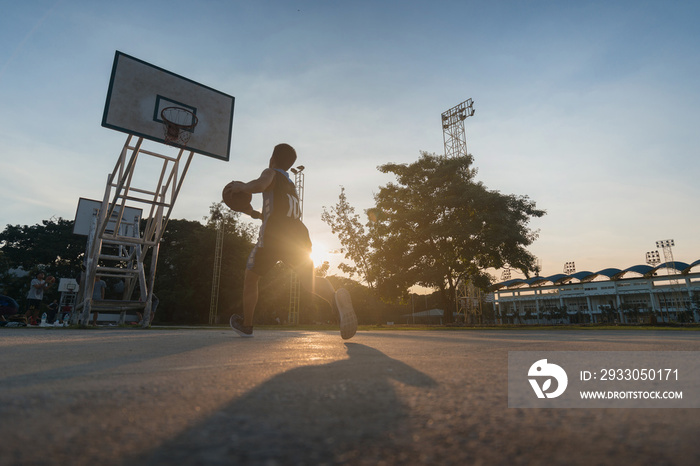 Basketball players playing basketball outdoor.