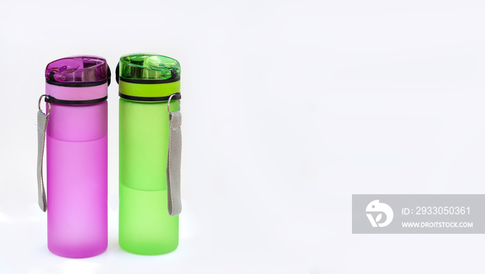 Two sports bottles (drinkers) with water isolated on a white background. The concept of drinking pure water