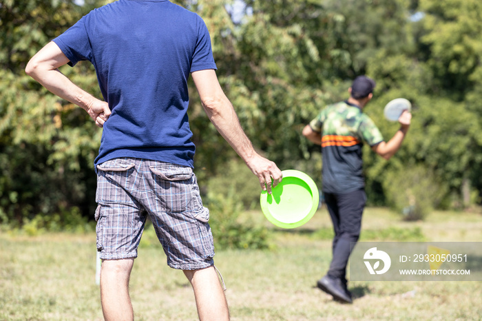 Playing flying disc golf sport game in the park