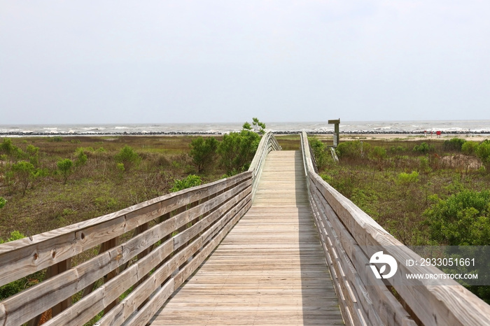 Louisiana wildlife and nature background. Way to the deserted beach area along wooden boardwalk over the sand dunes at the Grand Isle State Park, Louisiana, South USA.