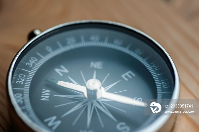 Close up vintage compass on wooden table, direction for tourist and Traveler hiking