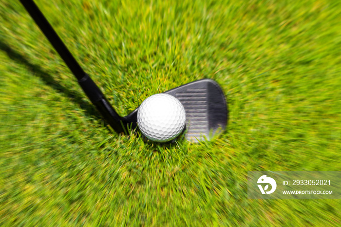 Closeup of hitting golf ball with golf iron club golf course wih motion blur effect