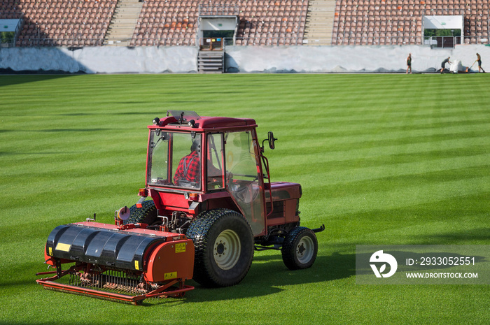 Man in tractor aerating a soccer field.