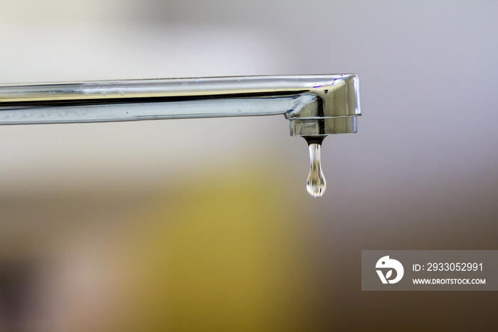 Close-up of faucet with turned drop water in modern bathroom. Horizontal crop with shallow depth of field