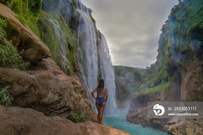 young woman taking picture,Amazing crystalline blue water of Tamul waterfall at Huasteca Potosina in San Luis Potosi, Mexico