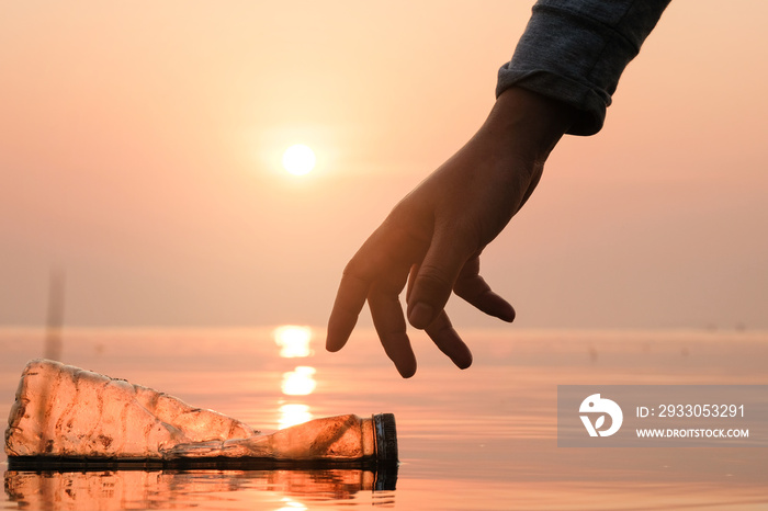 Hand Woman picking up empty of plastic bottle cleaning on the beach , volunteer concept. Environmental pollution. Ecological problem.