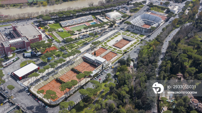 Aerial view of the red clay tennis courts of the Foro Italico, a sports facility in Rome hosting the Italian international tournament. In the background the main stadium.