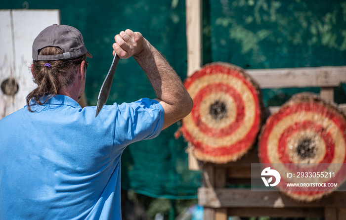 A man is ready for throwing knife on competition.