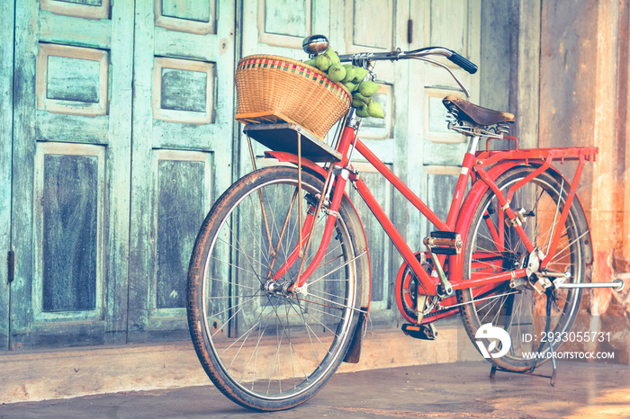 Hipster red bicycle in old building walls background , color if vintage tone