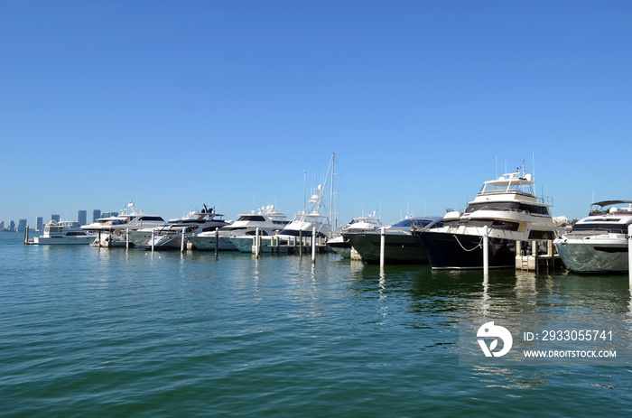 a row of upscale high-end cabby cruisers ,sport fishing boats and motor yachts moored in a Miami Beach,Florida marina