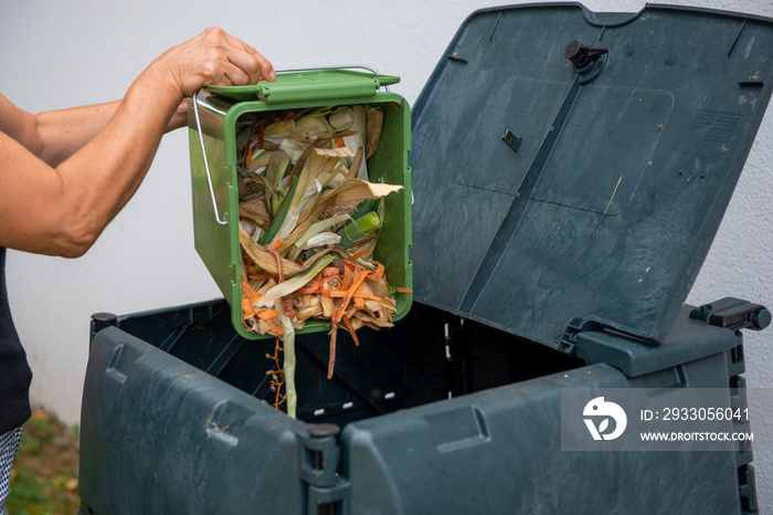 female emptying a bucketful of kitchen waste to the compost bin