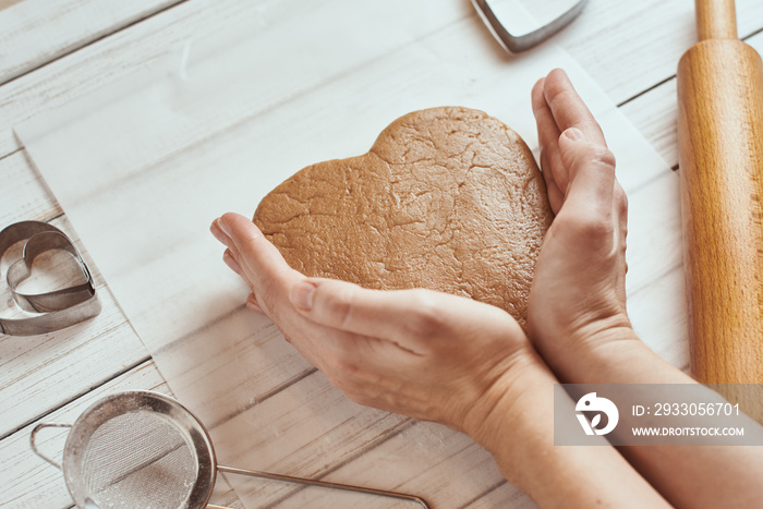 Woman kneads dough with hands in the kitchen