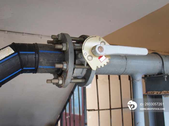 Butterfly valve with nuts and bolts. Water valve in the valve open position to control the water flow rate on the background of the concrete wall. Close focus and choose a subject