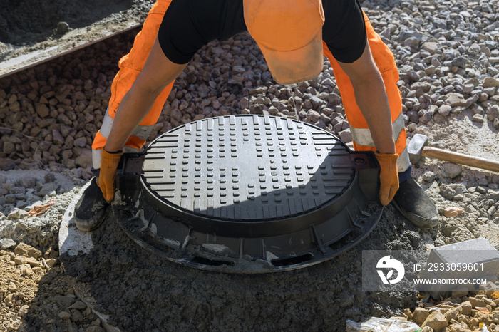 Installing cast iron sewer hatch on a concrete base of installation of water main sewer well in the ground