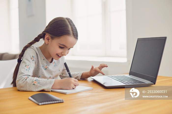 Online education of children. Girl schoolgirl learns a lesson online using a laptop video while sitting at a chat at home.