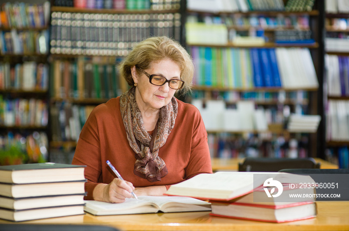 senior woman with books in library